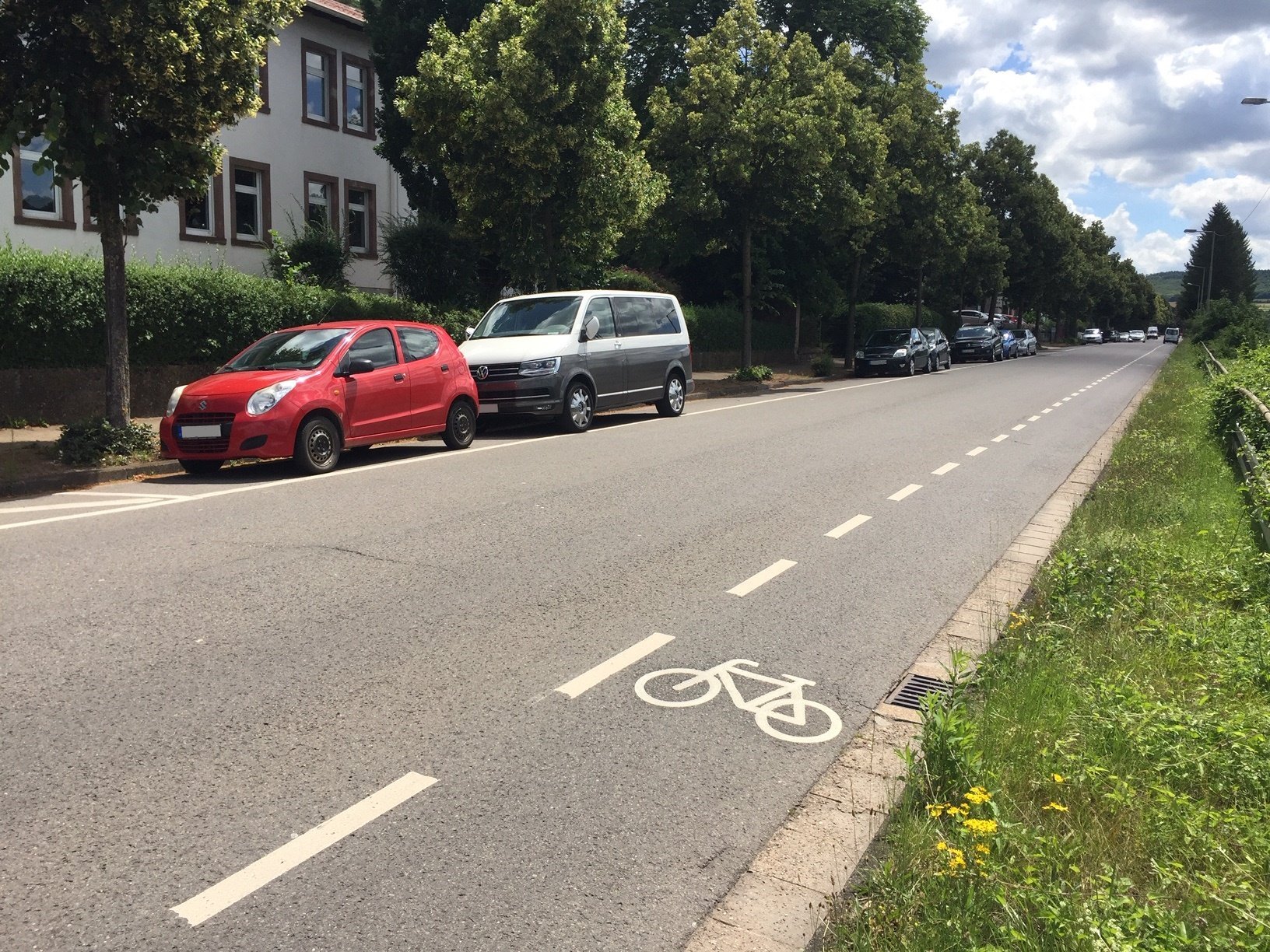 Das Bild zeigt den Radweg in der Saarbrücker Straße. Im Hintergrund sind zwei Autos zu sehen.