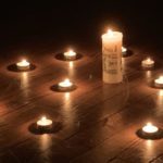 Das Bild zeigt eine Kerze und viele Teelichter, eine Aktion des Jugendhauses Merzig beim Lebendigen Adventskalender.