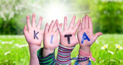 Das Foto zeigt vier Kinderhandflächen, auf jeder Handflächen steht ein Buchstabe, die zusammenhängend das Wort "KITA" ergeben.