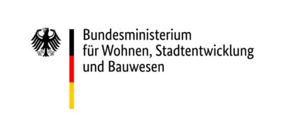 Das Foto zeigt das Logo des Bundesministeriums für Wohnen, Stadtentwicklung und Bauwesen: Dieses zeigt den Bundesadler in Schwarz, daneben einen senkrechten Streifen in den Farben der Deutschlandflagge (schwarz, rot, gold) sowie daneben den Titel des Bundesministeriums.