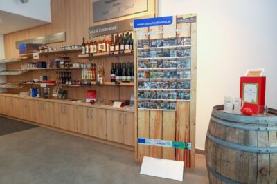 Das Foto zeigt ein Regal und einen Info-Ständer in der Tourist-Info.