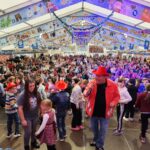 Das Foto zeigt Sänger Markus Becker auf der Bühne im Festzelt mit vielen Kindern.