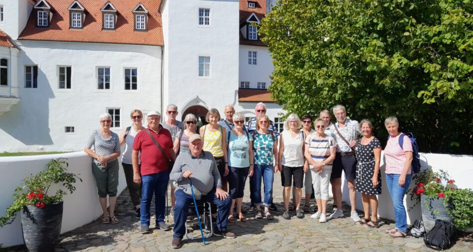 Das Foto zeigt einige Teilnehmende der Partnerschaftstage in Luckau 2023, im Hintergrund ist das Wasserschloss in Luckau zu sehen.