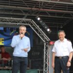Oberbürgermeister Marcus Hoffeld und Löschbezirksführer Jürgen Lamest auf der Bühne, Marcus Hoffeld hat ein Mikrofon in der Hand