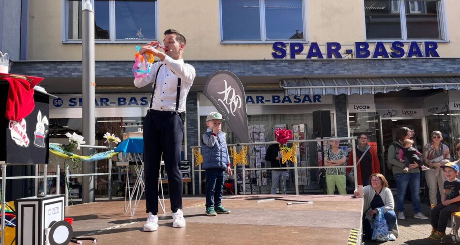 Lukas Hefner zaubert mit einem Kind aus dem Publikum beim Merziger Kindersommer 2024.