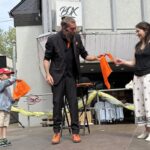 Kalibo zaubert mit einer Frau und einem Kind aus dem Publikum beim Merziger Kindersommer 2025.