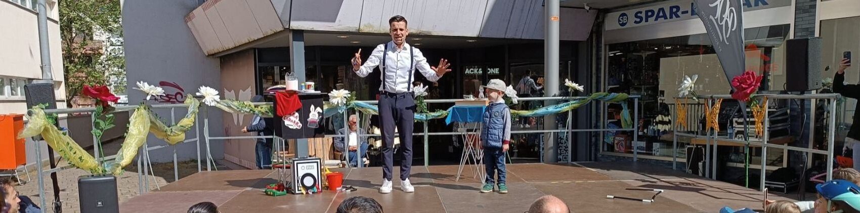 Lukas Hefner zaubert mit einem Kind aus dem Publikum beim Merziger Kindersommer 2024.