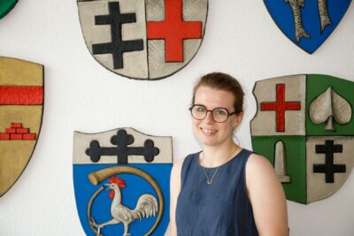 Mareike Jungblut, die Beauftragte für die Belange von Menschen mit Behinderung, vor der Wappenwand im Neuen Rathaus