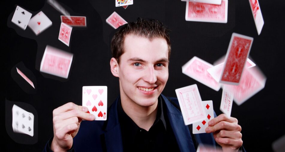 Zauberer Maxim Maurice, um ihn herum fliegen Spielkarten