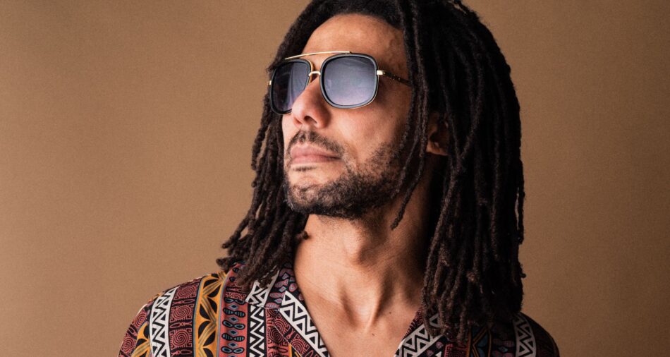 OQMan trägt eine Sonnenbrille und schaut nach links