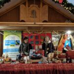 Pia Schäfer und eine Frau stehen in einem dekorierten Weihnachtshäuschen