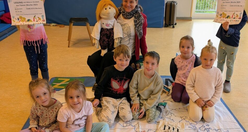 Kinder sitzen auf einer Decke, Frau mit Handpuppe sitzt dabei, Kinder halten Plakate