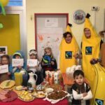 Verkleidete Kinder und Erzieherinnen vor einem Frühstücksbuffet