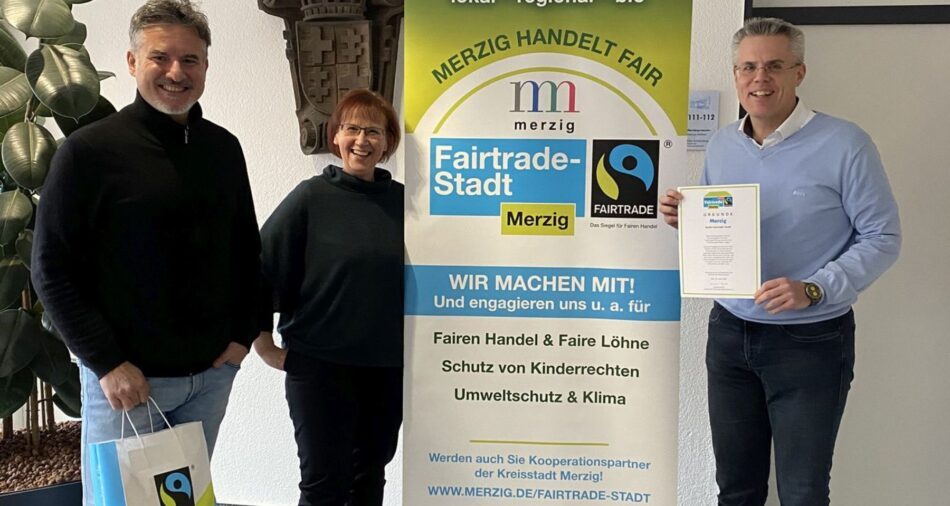 Christian Bies, Pia Schäfer und Marcus Hoffeld mit Urkunde, Banner und Merchandise