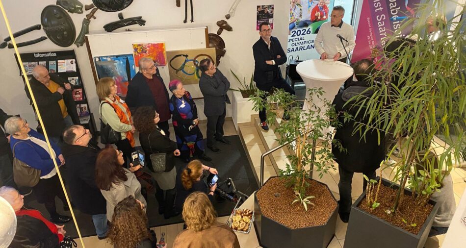 Marcus Hoffeld spricht am Mikrofon, um ihn herum stehen Menschen, Foto wurde von oben fotografiert