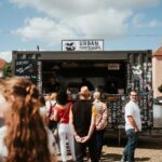 Foodtruck auf einem Street-Food-Festival, im Vordergrund stehen viele Menschen