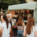 Foodtruck auf einem Street-Food-Festival, im Vordergrund stehen viele Menschen