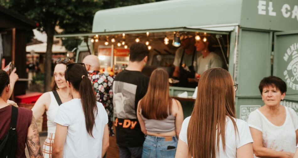 Foodtruck auf einem Street-Food-Festival, im Vordergrund stehen viele Menschen