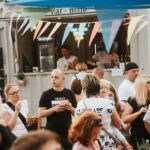 Foodtruck auf einem Street-Food-Festival, im Vordergrund stehen viele Menschen