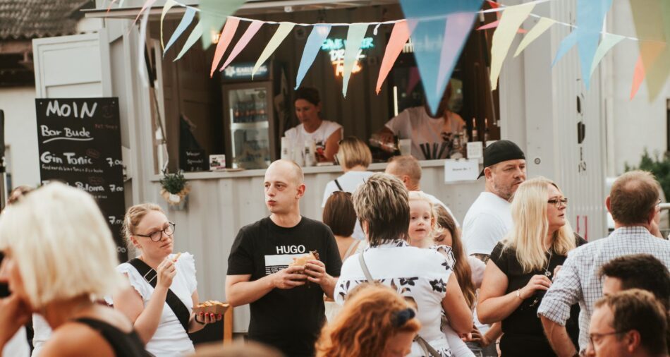 Foodtruck auf einem Street-Food-Festival, im Vordergrund stehen viele Menschen