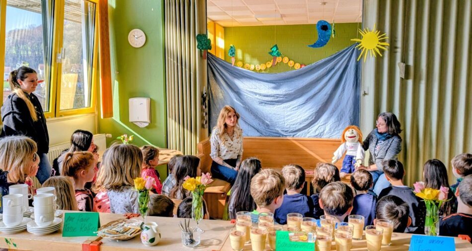 Kinder hören gespannt einer Handpuppe zu