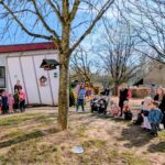 Kinder und Erwachsene stehen auf einem Spielplatz