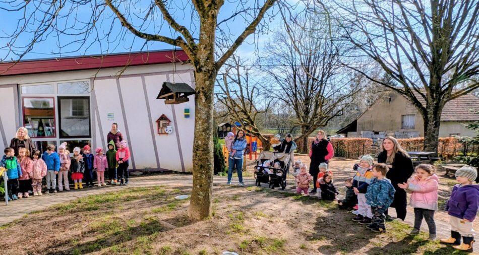 Kinder und Erwachsene stehen auf einem Spielplatz