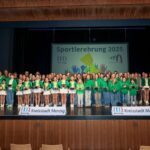 Geehrte Sportlerinnen und Sportler bei der Sportlerehrung 2025, sie stehen auf der Bühne und halten ein Geschenk in der Hand