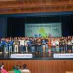 Geehrte Sportlerinnen und Sportler bei der Sportlerehrung 2025, sie stehen auf der Bühne und halten ein Geschenk in der Hand