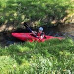 Junge paddelt im Kanu im Seffersbach