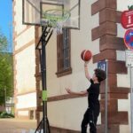 Junge wirft einen Basketball in einen Basketballkorb