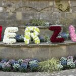 Buchstaben aus bunten Blumen ergeben das Wort Merzig