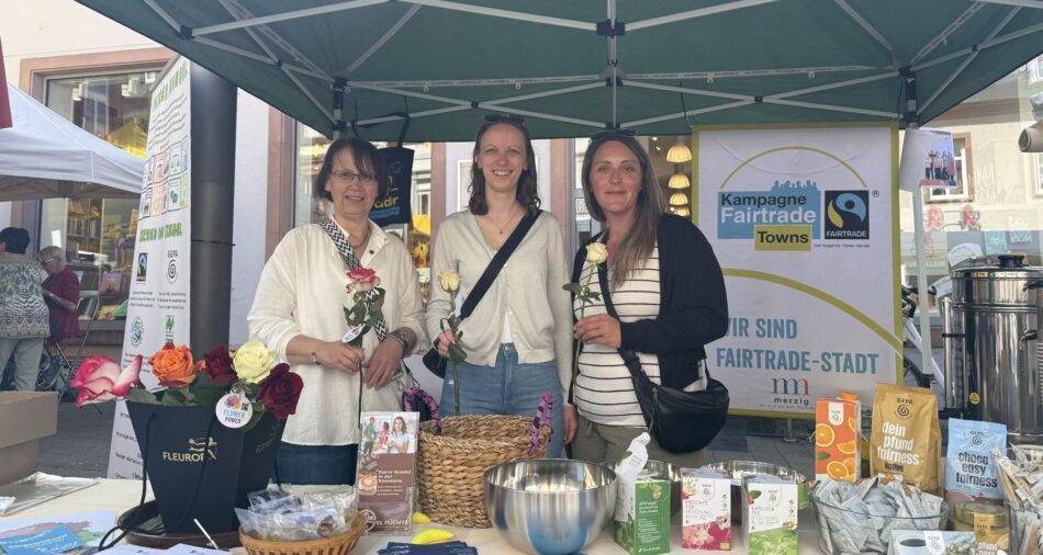 Drei Frauen mit Rosen hinter einem Stand