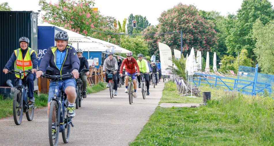 Zahlreiche Menschen auf Fahrrädern radeln an der Saar