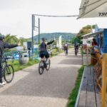 Männer auf Fahrrädern winken fröhlich zur Seite