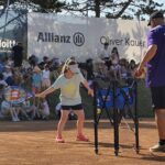 Mädchen mit Tennisschläger schlägt nach Ball