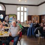 Größere Menschengruppe beim Frühstück