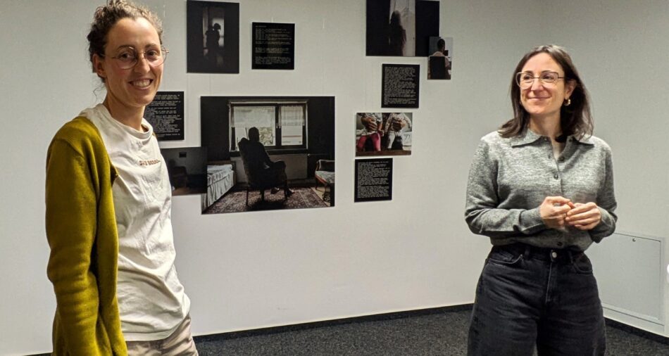 Zwei Frauen, im Hintergrund hängen Fotografieren an einer Wand