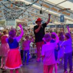 Markus Becker tanzt auf der Bühne mit Kindern beim Oktoberfest